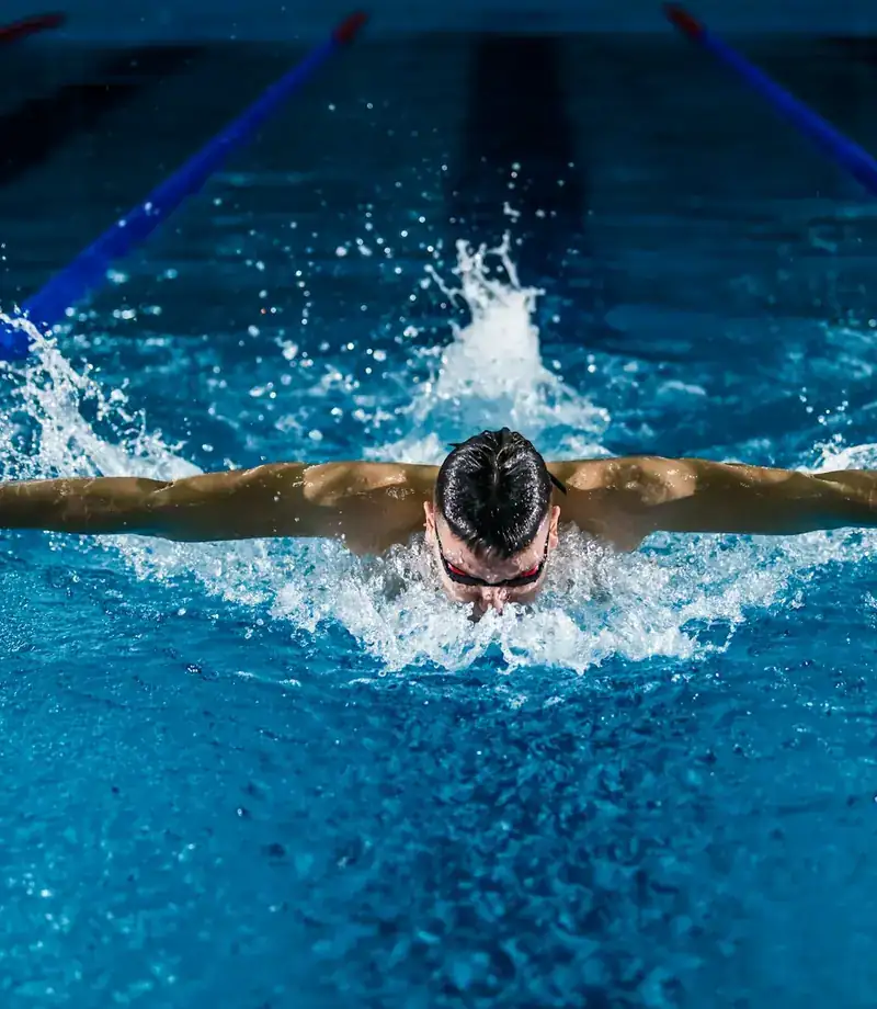 Nadador em prova de borboleta na piscina